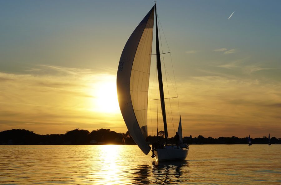 A sailboat at sunset on calm water